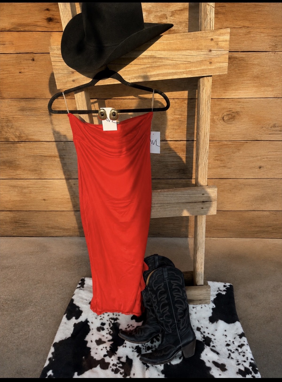 Bright red side slit dress on ladder with cowboy hat and boots